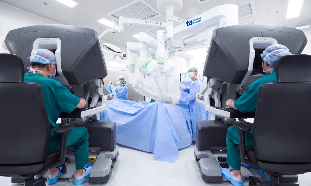 Hai chuyên gia cùng điều khiển robot phẫu thuật cho bệnh nhân. Ảnh: Bệnh viện đa khoa Tâm Anh