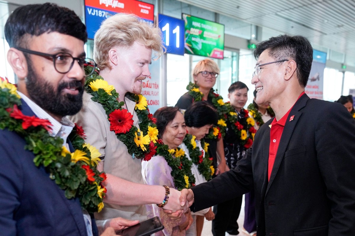 Lãnh đạo Vietjet tặng hoa và chào đón hành khách trên chuyến bay đầu tiên. Nguồn: Vietjet.