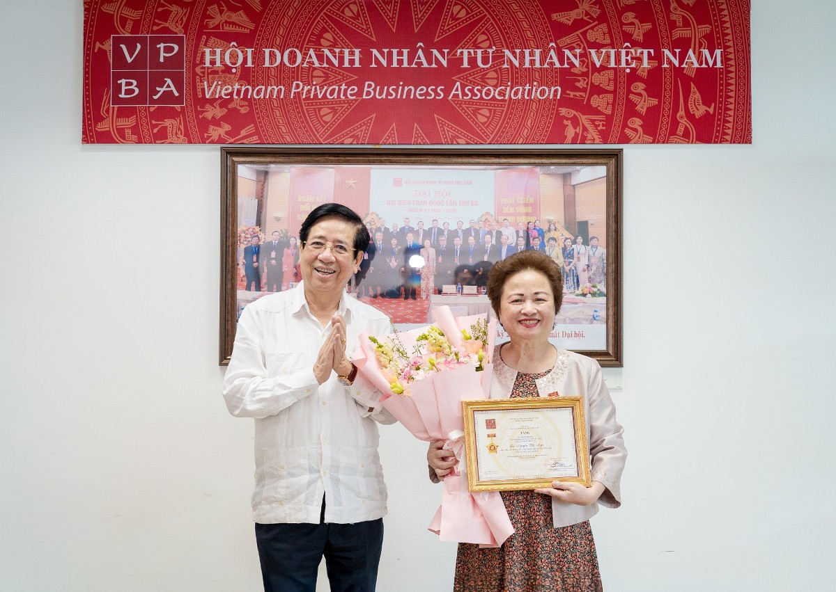 PGS.TS Nguyễn Trọng Điều trao kỷ niệm chương và hoa tặng Bà Nguyễn Thị Nga.