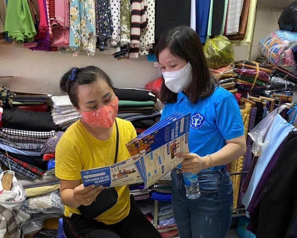 Cán bộ bảo hiểm xã hội thông tin chính sách bảo hiểm đến người dân. Ảnh: Duy Nguyễn.
