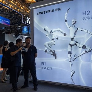 Khách tham quan đứng gần quảng cáo của Unitree Robotics, một công ty robot hình người thương mại hàng đầu của Trung Quốc, tại Hội nghị Trí tuệ nhân tạo thế giới - 2026 ở Thượng Hải, Trung Quốc. Ảnh: AP/Ng Han Guan.