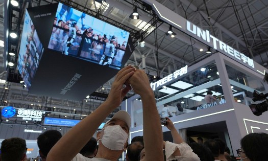 Khách tham quan Hội nghị Robot Thế giới chụp ảnh selfie gần gian hàng của Unitree tại Bắc Kinh. Ảnh: AP/Ng Han Guan