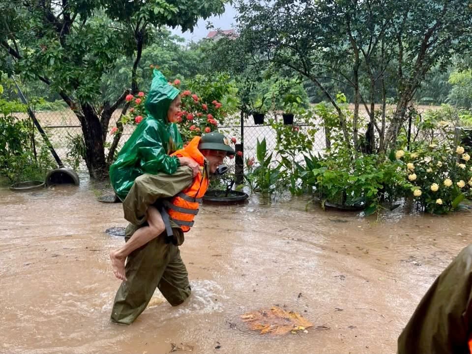 Lực lượng Công an xã Lao Bảo hỗ trợ di dời người dân ra khỏi vùng nguy hiểm. Ảnh: Công an xã Lao Bảo