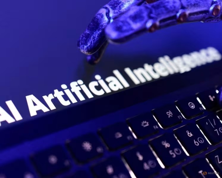 Ảnh minh họa với dòng chữ "AI Artificial Intelligence", bàn phím và một bàn tay robot. Ảnh: Reuters/Dado Ruvic.