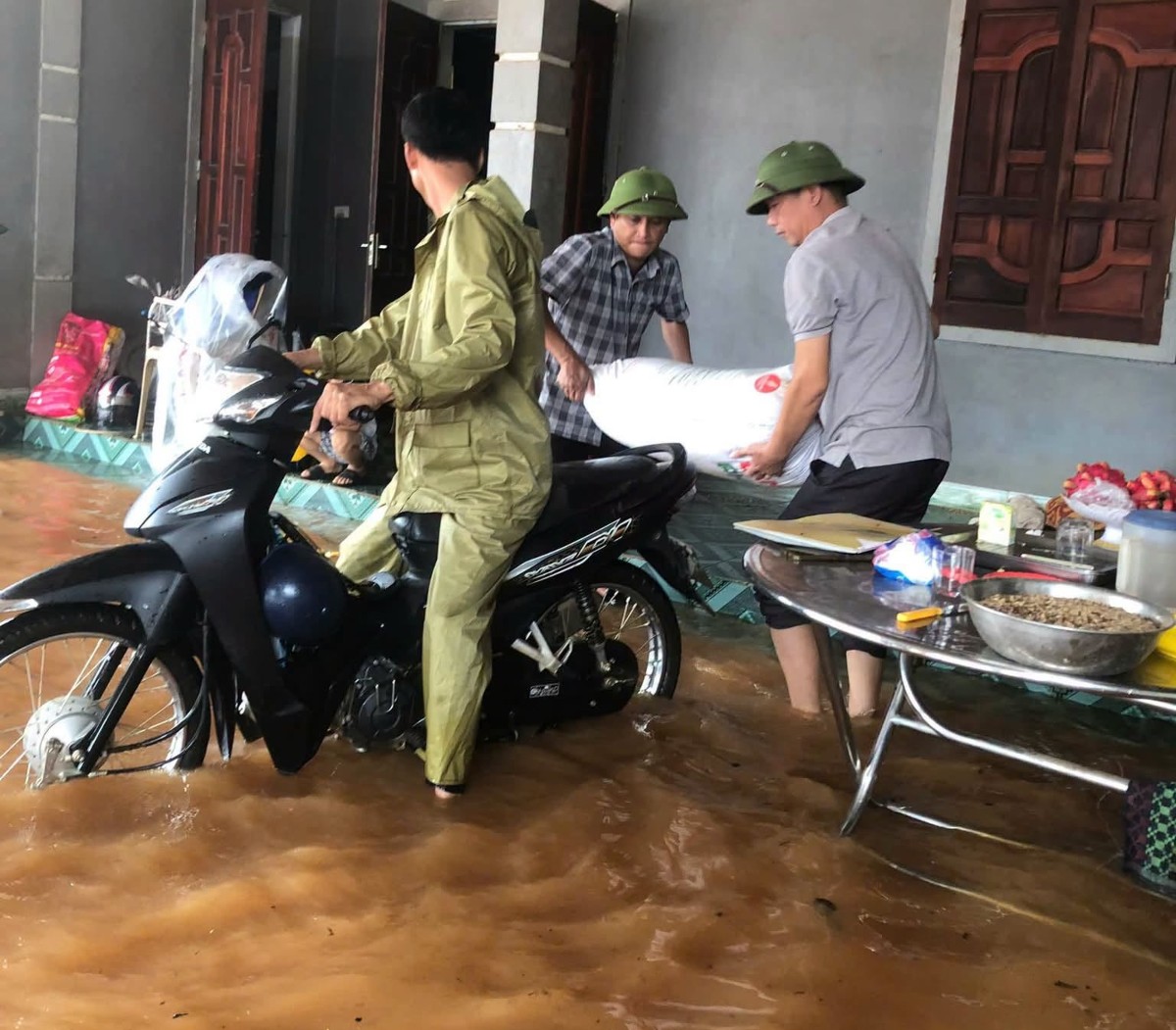 Lực lượng chức năng xã Nghĩa Lộc hỗ trợ người dân di chuyển người và vật nuôi khỏi khu vực ngập sâu.