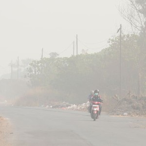Người dân di chuyển bằng xe máy trên một tuyến đường giữa lớp khói mù do cháy rừng tại Palembang, Nam Sumatra, Indonesia. Ảnh: AP/Muhammad Hatta.