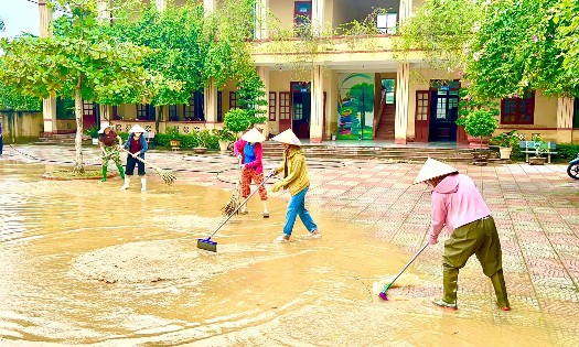 Cán bộ, giáo viên Trường THCS Nông Cống, phân hiệu Vạn Thiện khẩn trương vệ sinh trường học sau khi nước lũ rút. Ảnh: Nguyễn Thuấn