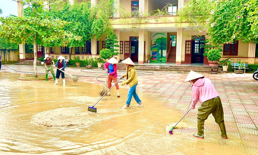 Cán bộ, giáo viên Trường THCS Nông Cống, phân hiệu Vạn Thiện khẩn trương vệ sinh trường học sau khi nước lũ rút. Ảnh: Nguyễn Thuấn