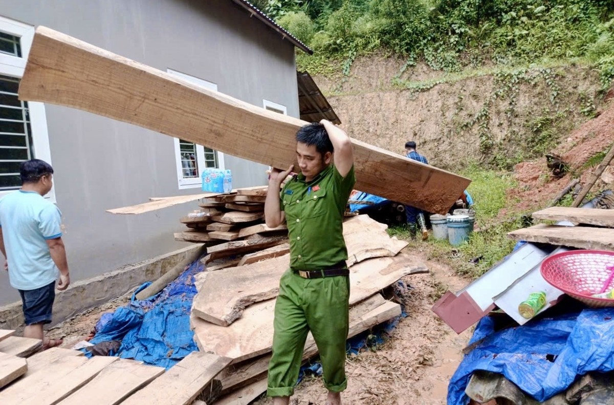 Công an xã Điền Quang giúp người dân dọn đất đá, bùn đất tràn vào nhà sau mưa lớn. Ảnh: Công an Thanh Hóa