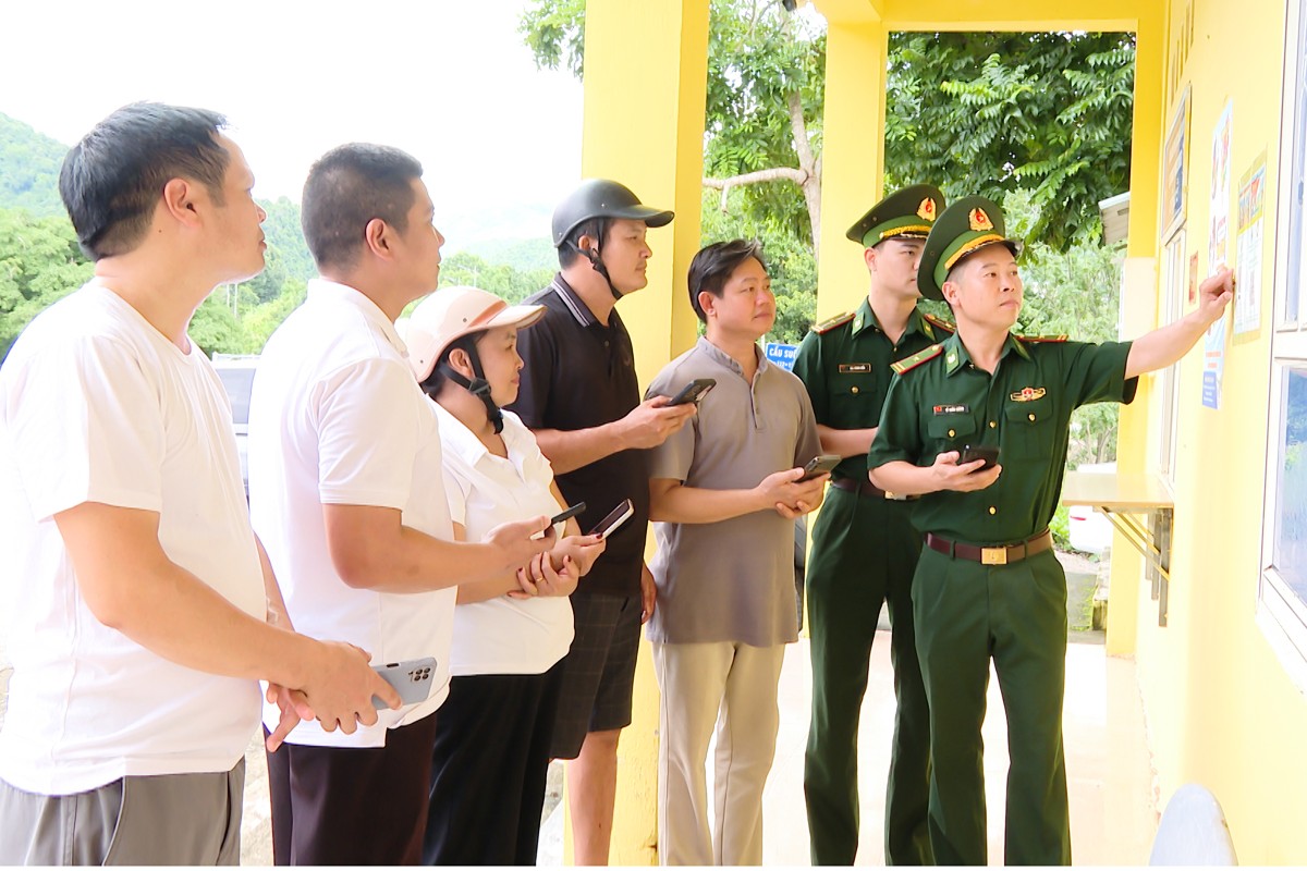 Cán bộ Đồn Biên phòng cửa khẩu Tén Tằn hướng dẫn người dân sử dụng tiện ích số, làm thủ tục qua lại biên giới và quét mã QR tiếp nhận tin báo, tố giác tội phạm tại Trạm cửa khẩu Tén Tằn. Ảnh: Nguyễn Thuấn