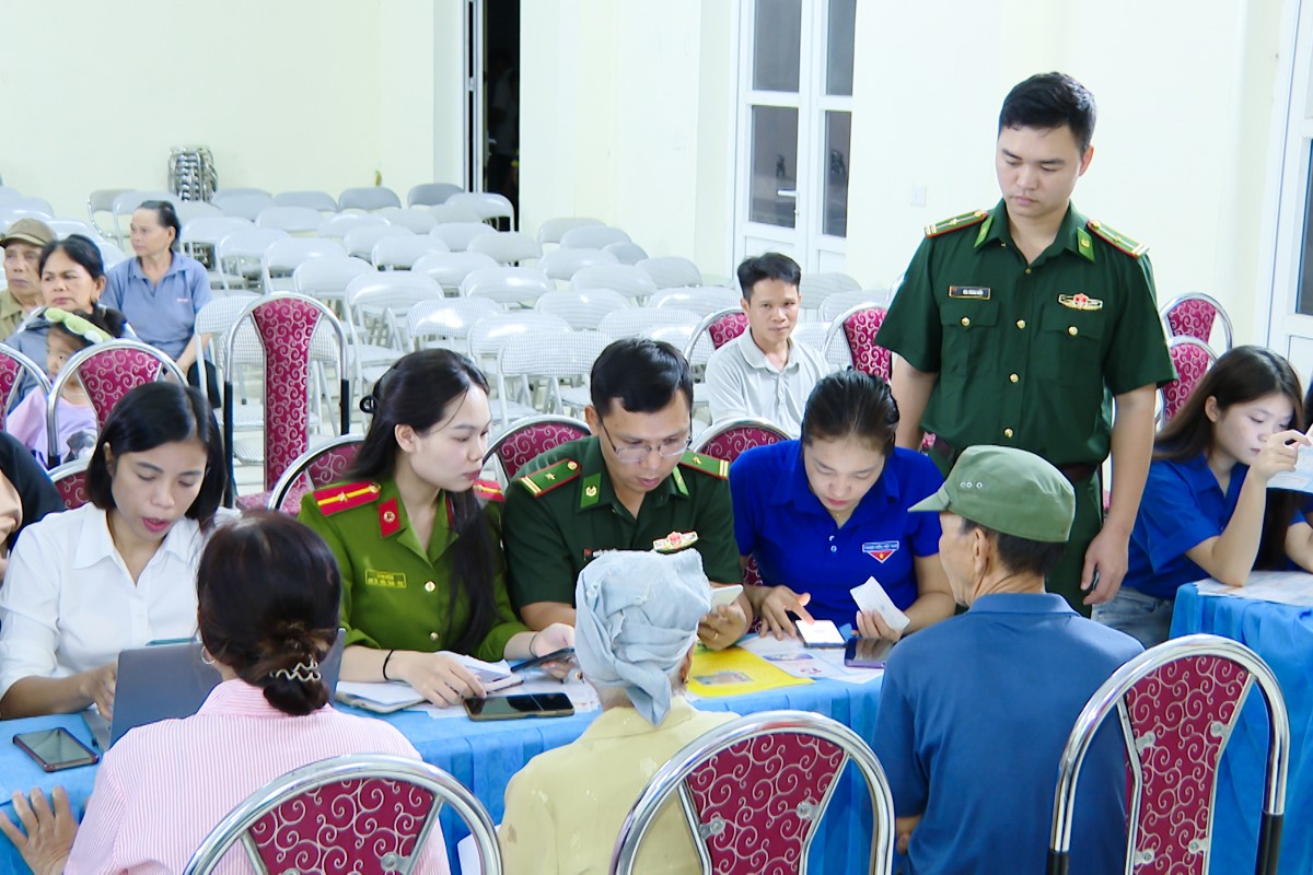 Cán bộ Đồn Biên phòng cửa khẩu Tén Tằn hướng dẫn người dân xã Mường Lát sử dụng các tiện ích số trên điện thoại thông minh. Ảnh: Nguyễn Thuấn