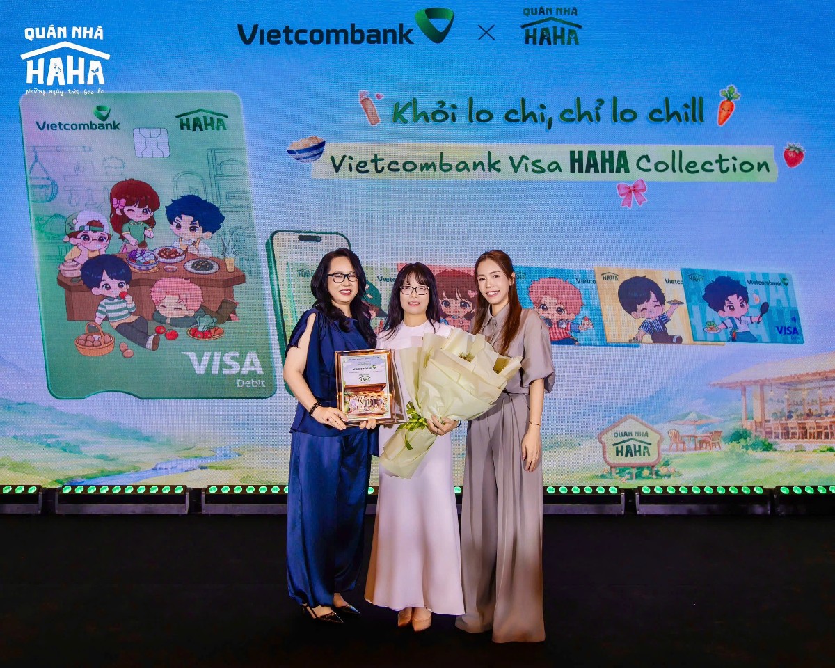 Bà Đoàn Hồng Nhung - Thành viên Ban điều hành, Giám đốc Khối Bán lẻ Vietcombank (ở giữa) đại diện ngân hàng nhận hoa và biểu trưng từ đơn vị sản xuất tại họp báo ra mắt Quán Nhà Haha.