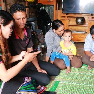 Cán bộ xã Nam Ka tuyên truyền, hướng dẫn người dân chủ động tiếp cận thông tin qua điện thoại di động. Ảnh: Thanh Xuân.