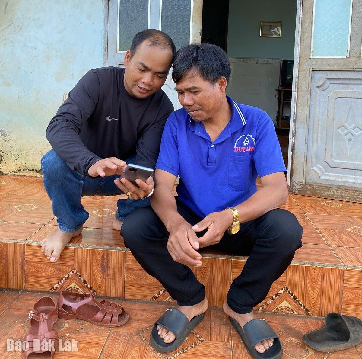 Buôn trưởng Y Bhăng Niê (bìa trái) ở buôn Tah, xã Cuôr Đăng đến tận nhà để phổ cập tri thức số cho người dân. Ảnh: Báo Đắk Lắk.