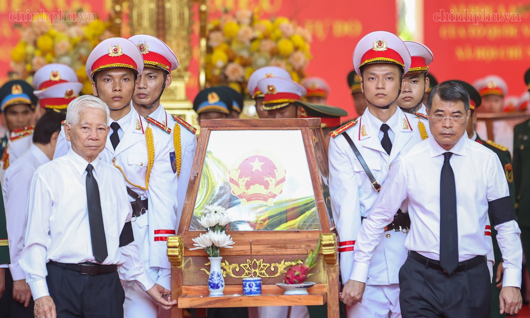 Thủ tướng Chính phủ Lê Minh Hưng và nguyên Chủ tịch nước Nguyễn Minh Triết di chuyển giá khiêng hài cốt liệt sĩ lên xe để đến Nghĩa trang liệt sĩ Thành phố Hồ Chí Minh - Ảnh: chinhphu.vn/Nhật Bắc