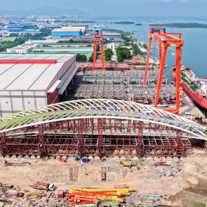Khối vòm thép nhịp chính cầu đi bộ đã hoàn thành thử tải tại nhà máy, chờ lai dắt về công trường để hợp long. Ảnh: Nutifood