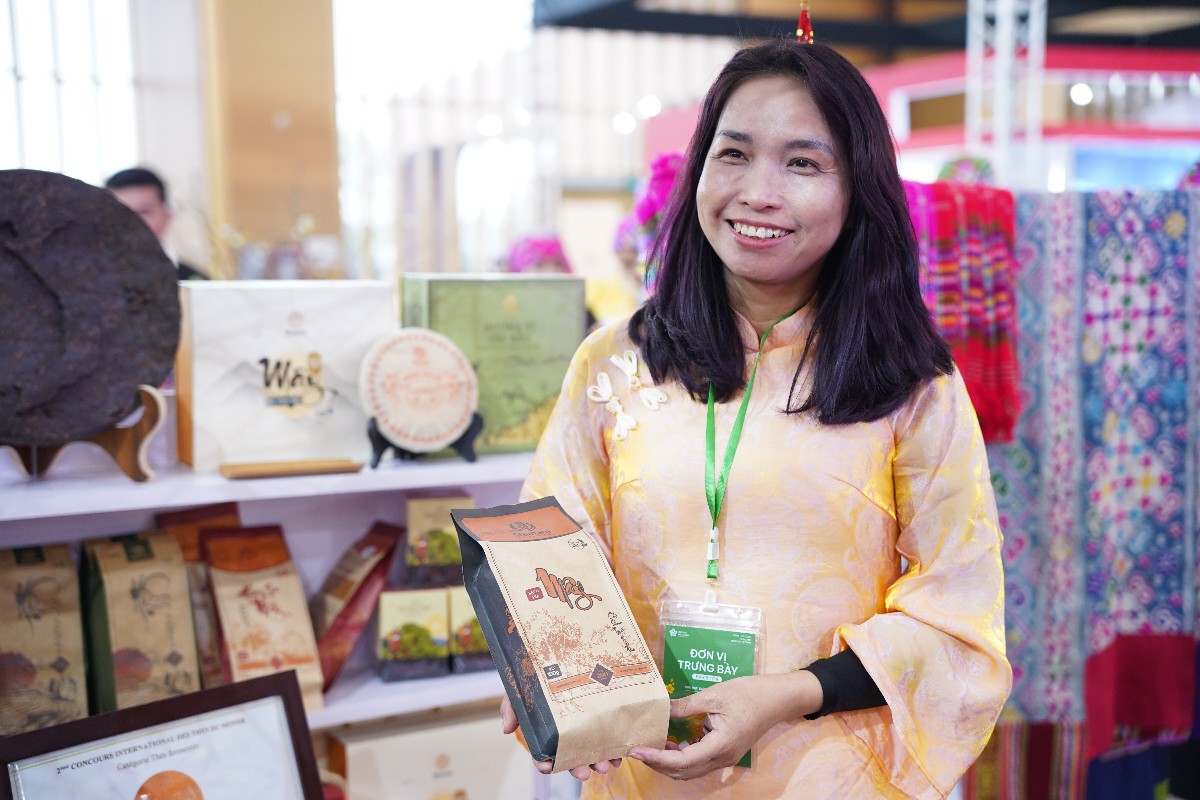 Bà Nguyễn Thị Thắm, Giám đốc Công ty trà và đặc sản Tây Bắc, giới thiệu sản phẩm trà tại một hội chợ xúc tiến thương mại. Ảnh: Phương Lan.