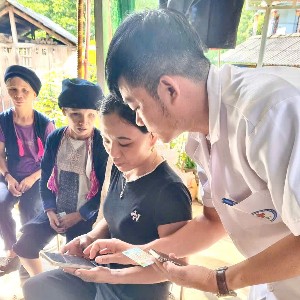Cán bộ trạm y tế hỗ trợ cài đặt Sổ sức khỏe điện tử trên ứng dụng VNeID cho người dân. Ảnh: Sở Y tế Lào Cai.