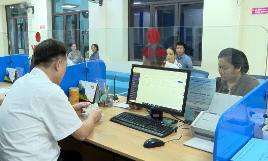 Cán bộ Trung tâm Phục vụ hành chính công tại tỉnh Lào Cai hướng dẫn người dân sử dụng “Trợ lý Nhân dân” để hoàn thiện hồ sơ trực tuyến. Ảnh: Báo Lào Cai.