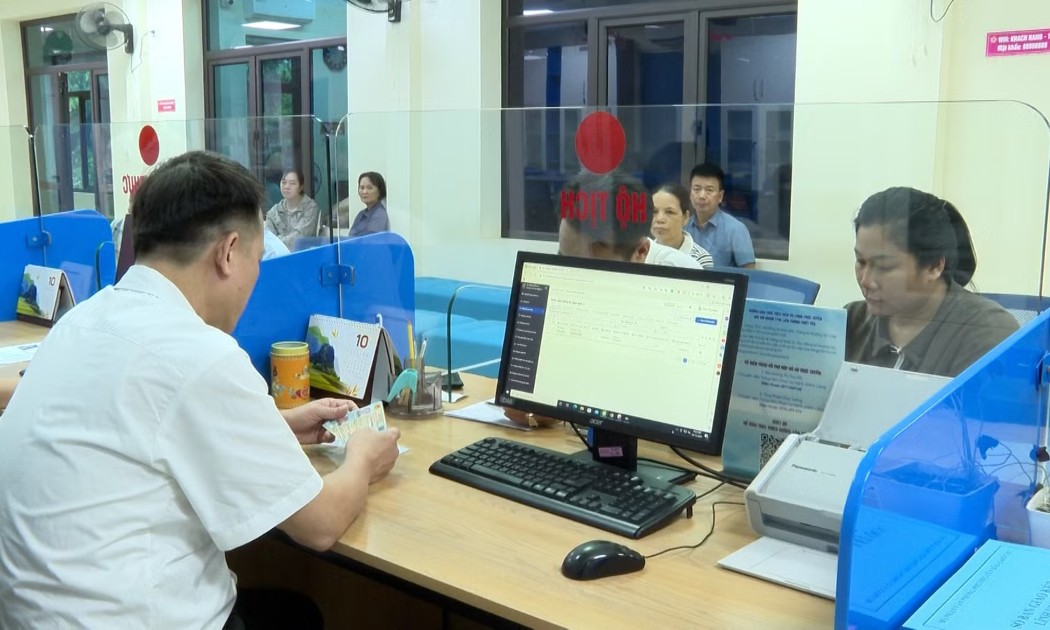 Cán bộ Trung tâm Phục vụ hành chính công tại tỉnh Lào Cai hướng dẫn người dân sử dụng “Trợ lý Nhân dân” để hoàn thiện hồ sơ trực tuyến. Ảnh: Báo Lào Cai.