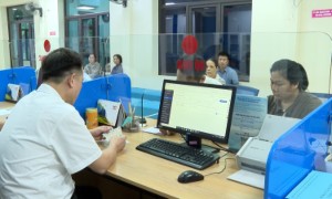 Cán bộ Trung tâm Phục vụ hành chính công tại tỉnh Lào Cai hướng dẫn người dân sử dụng “Trợ lý Nhân dân” để hoàn thiện hồ sơ trực tuyến. Ảnh: Báo Lào Cai.