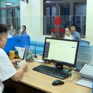 Cán bộ Trung tâm Phục vụ hành chính công tại tỉnh Lào Cai hướng dẫn người dân sử dụng “Trợ lý Nhân dân” để hoàn thiện hồ sơ trực tuyến. Ảnh: Báo Lào Cai.