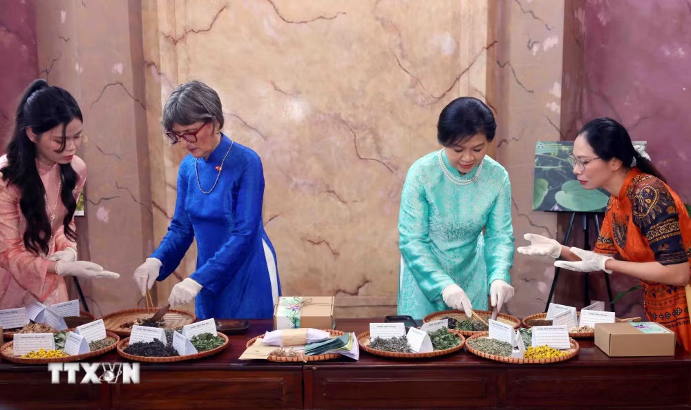 Bà Ngô Phương Ly, Phu nhân Tổng Bí thư, Chủ tịch nước Tô Lâm cùng bà Caroline Parmelin, Phu nhân Tổng thống Liên bang Thụy Sĩ trải nghiệm làm gối chườm từ thảo dược - Ảnh: TTXVN