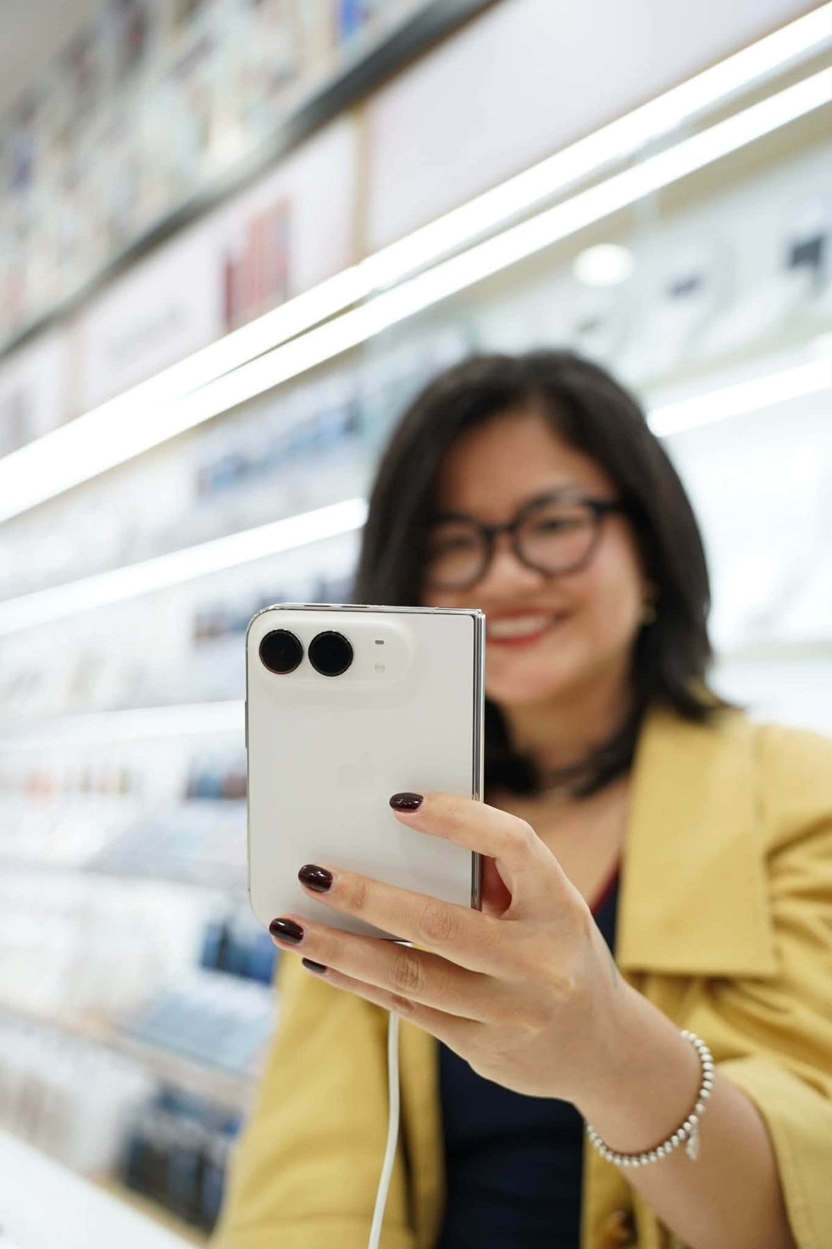 Nữ khách hàng trải nghiệm mua sắm iPhone Dou bản 256GB màu trắng ánh sao tại cửa hàng Minh Tuấn Mobile. Ảnh: Trang Đỗ.