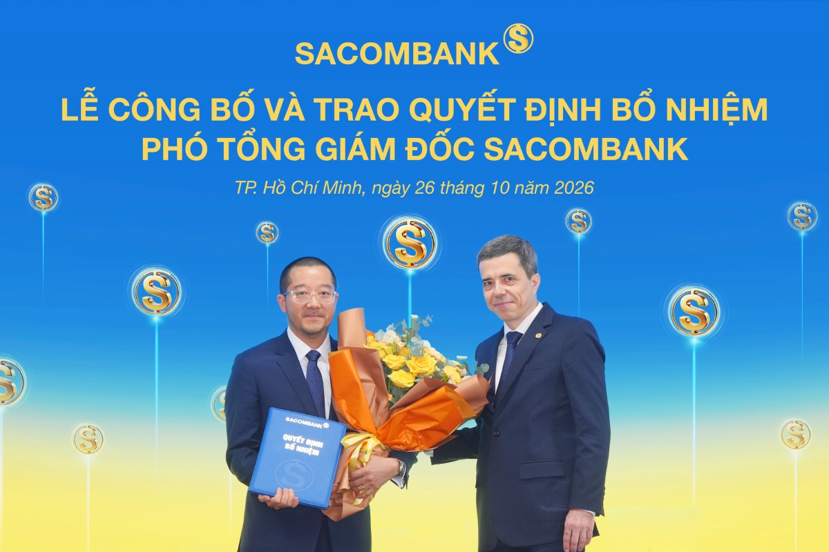 Ông Nguyễn Xuân Ái Quốc nhận quyết định bổ nhiệm và hoa chúc mừng từ ông Loic Faussier - Tổng giám đốc SACOMBANK.