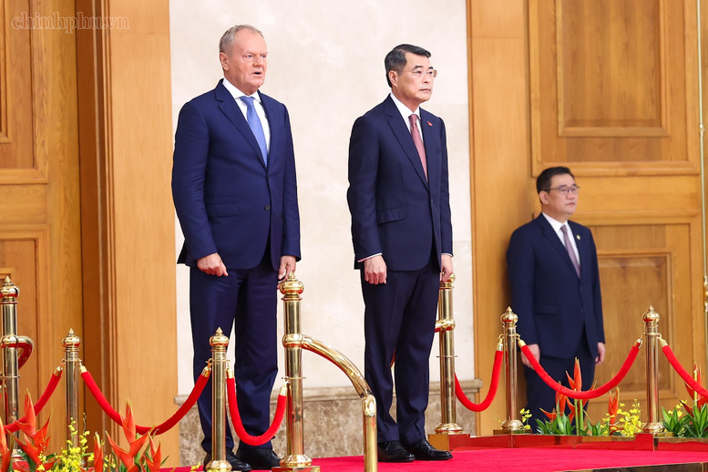 Thủ tướng Lê Minh Hưng và Thủ tướng Donald Tusk trên bục danh dự nghe Quân nhạc cử Quốc thiều hai nước - Ảnh: chinhphu.vn/Nhật Bắc