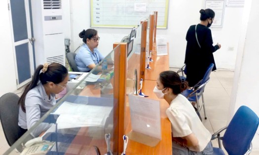 Workers process paperwork to receive social insurance benefits. (Photo: Thu Hang)