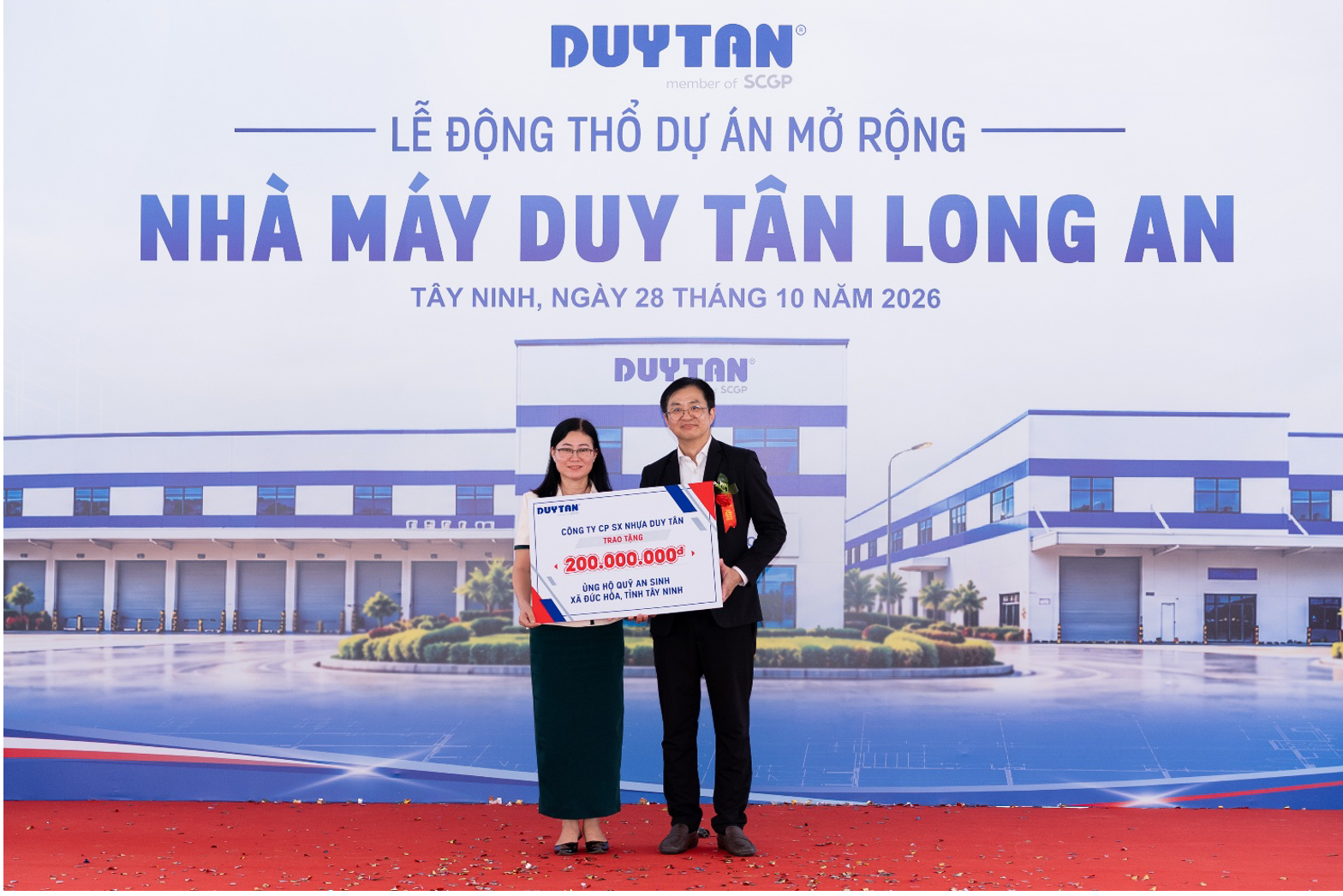 Mr. Virat Wongvarodom, Senior Executive Vice President, presents a symbolic donation check for VND200 million in support of the Duc Hoa Commune Social Welfare Fund to Ms. Le Thi Ngoc Hoa, Chairwoman of the Duc Hoa Commune People’s Committee.